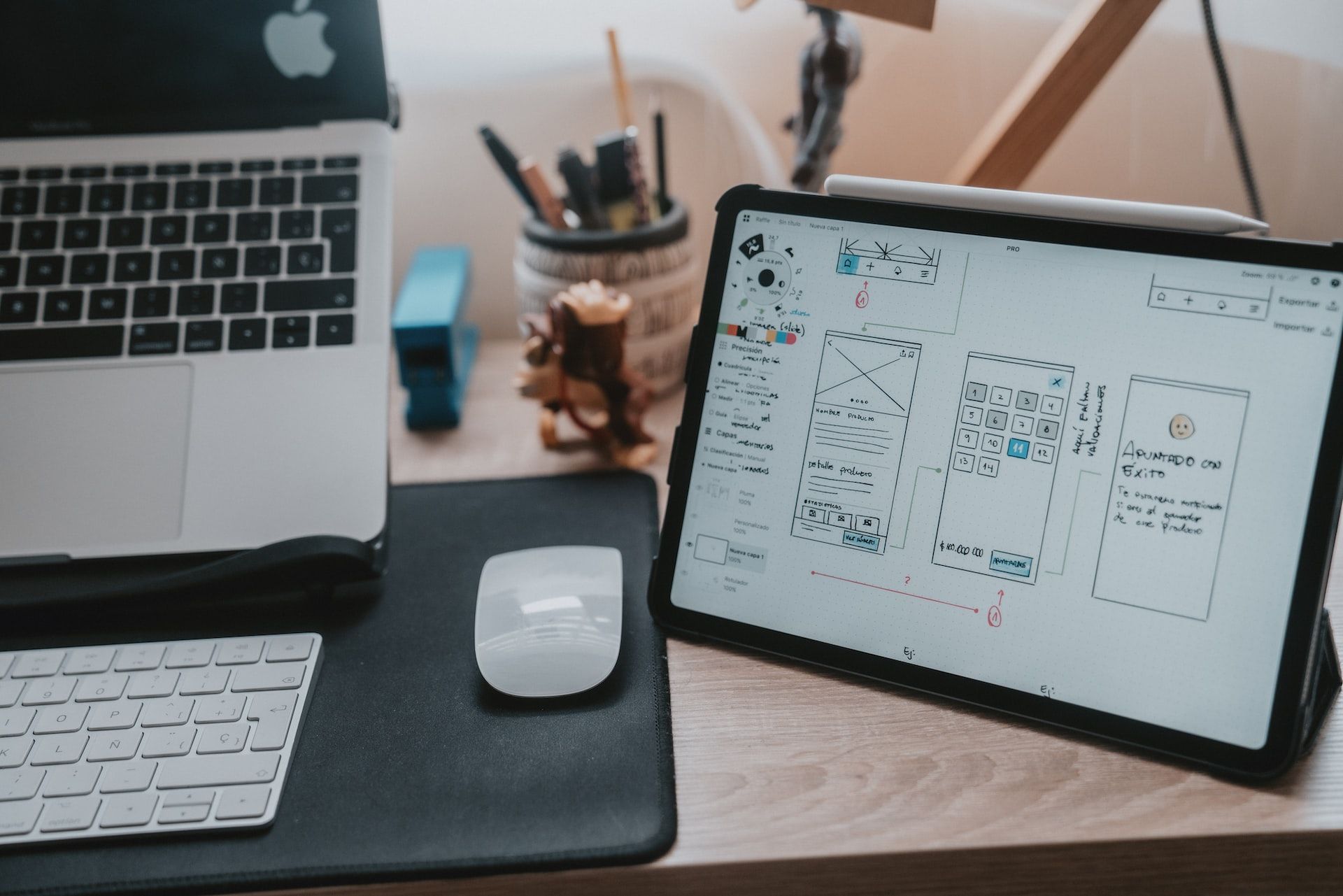 Uma imagem de um tablet com diversos wireframes e anotações.